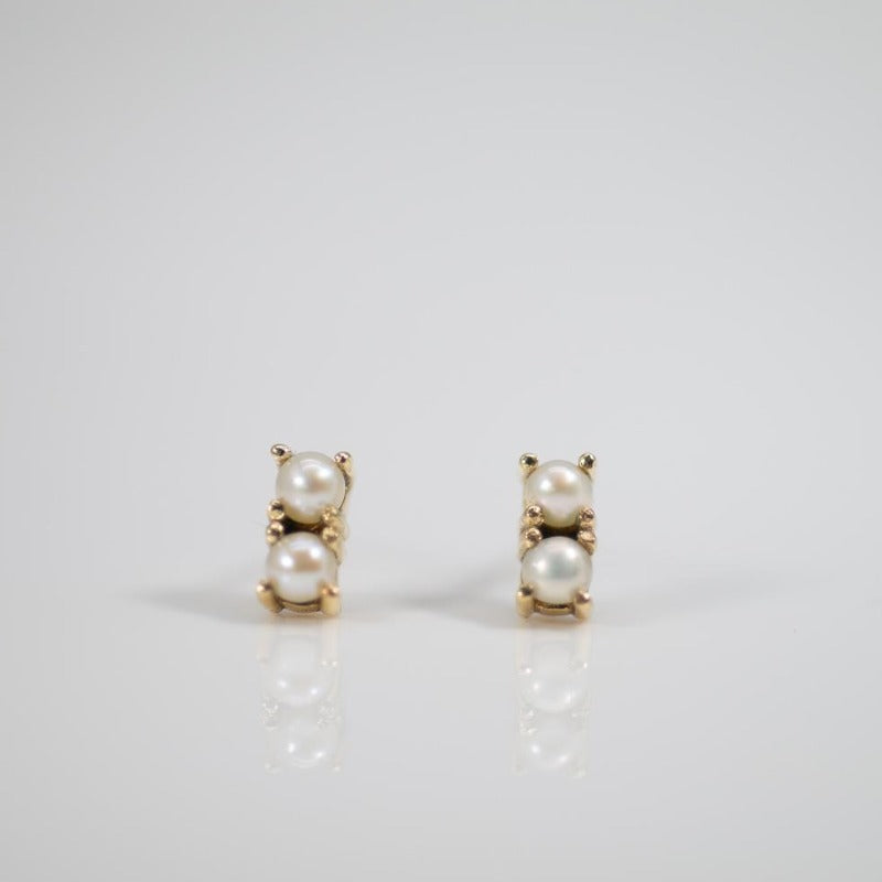 Two pearl pave studs in gold