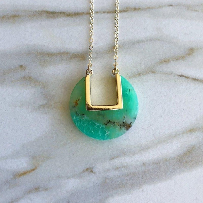 Model wearing blue coin-shaped necklace