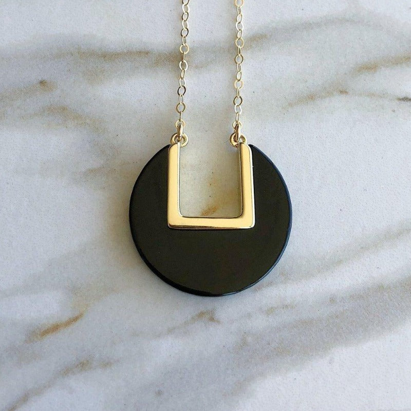 Model wearing blue coin-shaped necklace