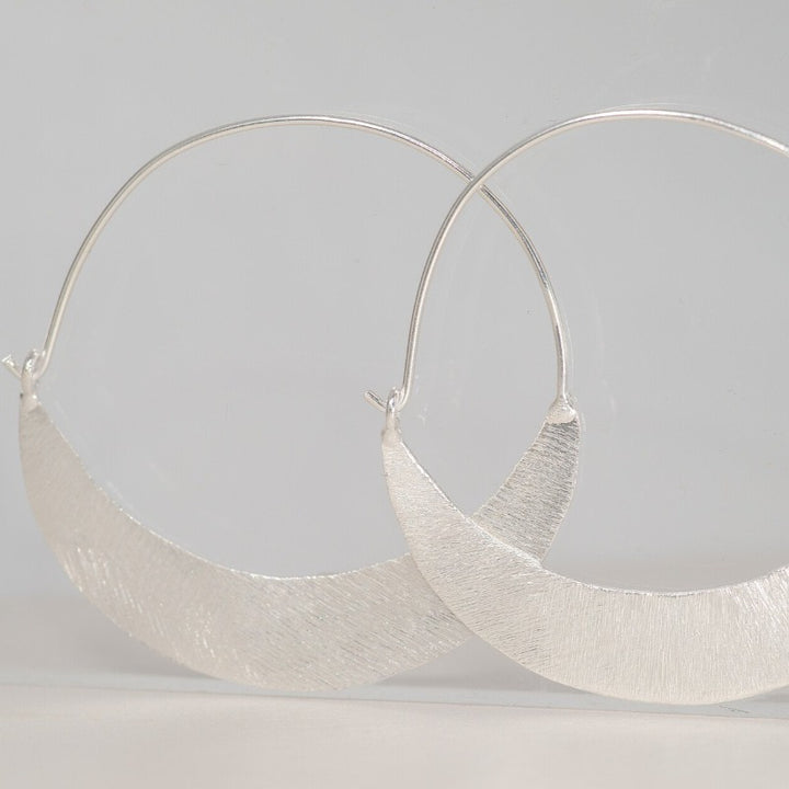 Silver crescent shaped hoop earrings