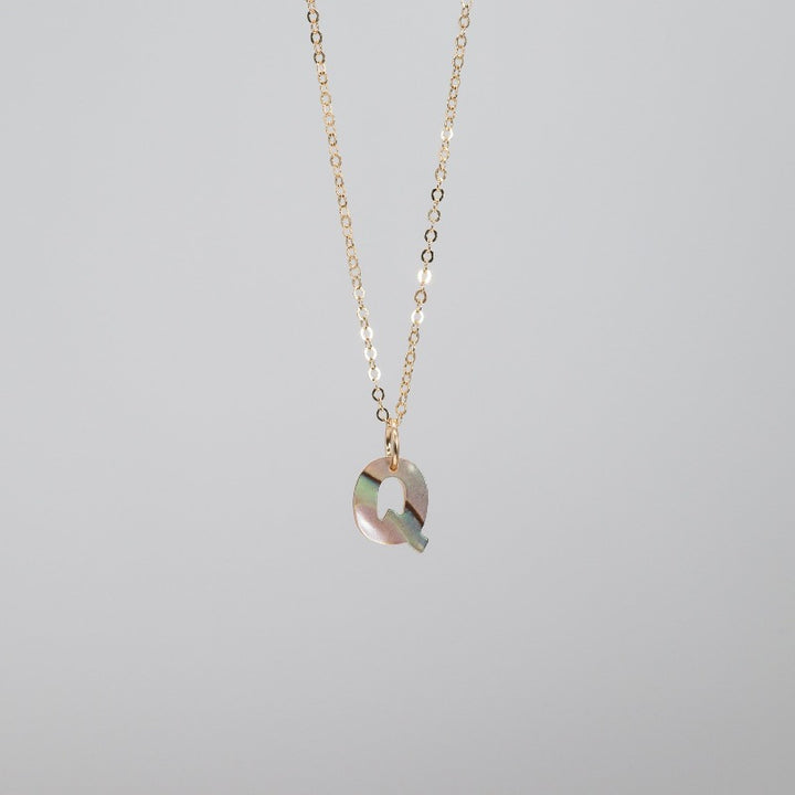 Small dainty abalone "Q" pendant on thin gold chain