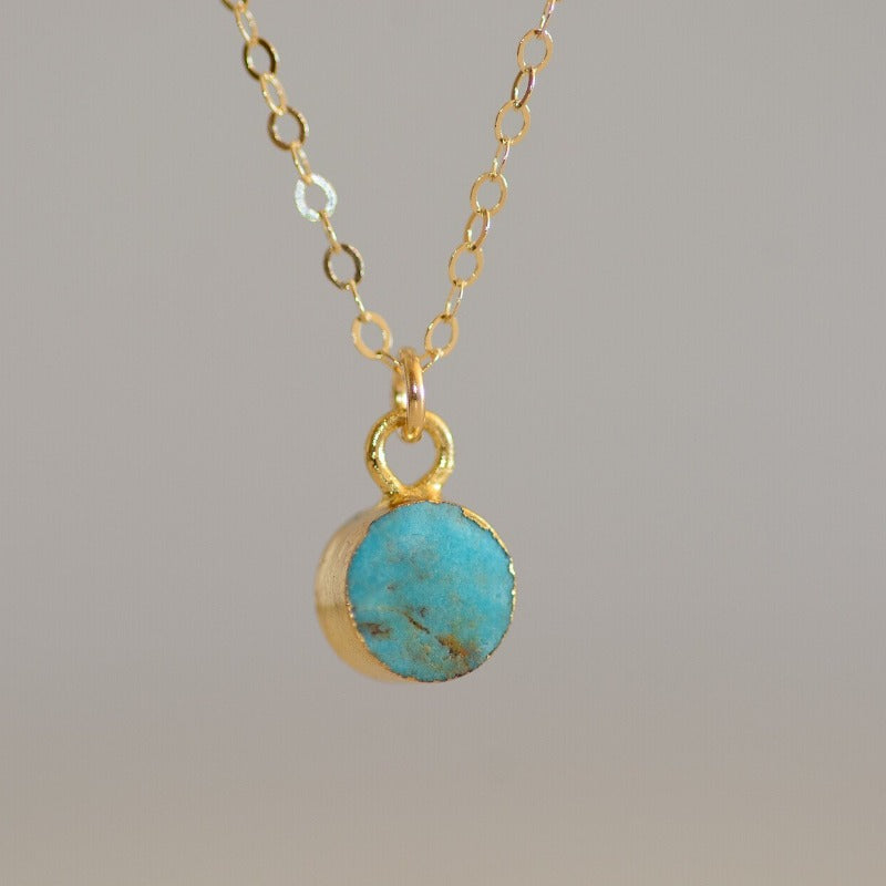 Tiny circular turquoise stone set in gold on dainty gold chain