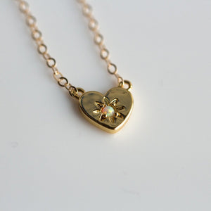 Gold heart charm necklace with a center opal stone