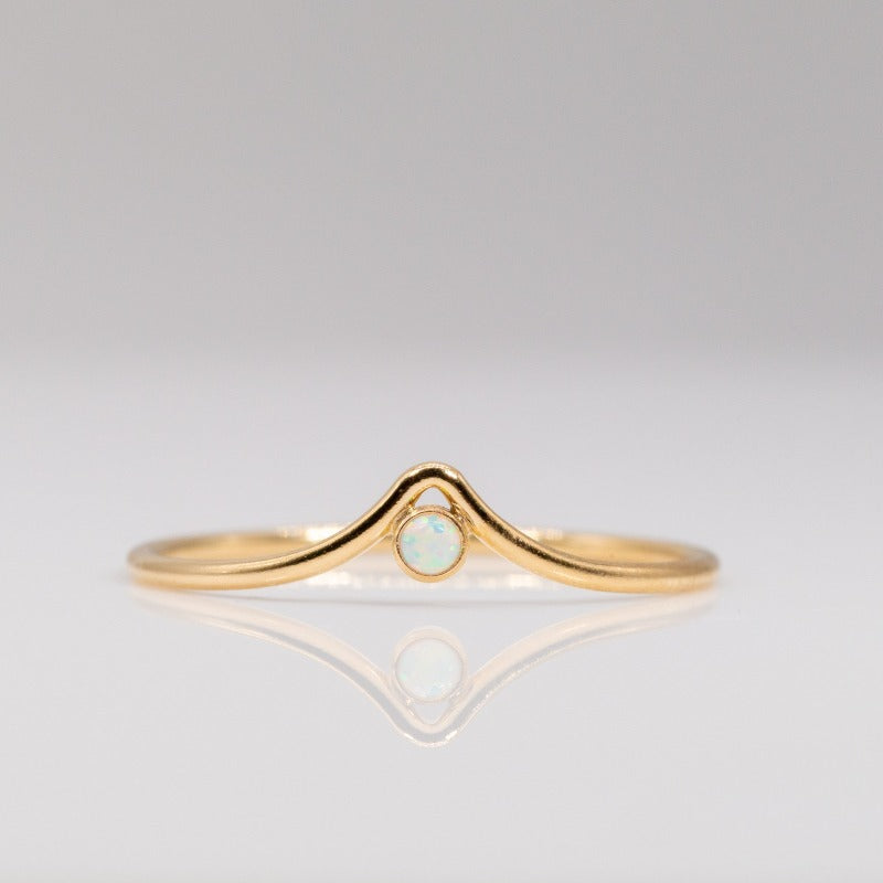Delicate gold ring with chevron arch and small round opal stone