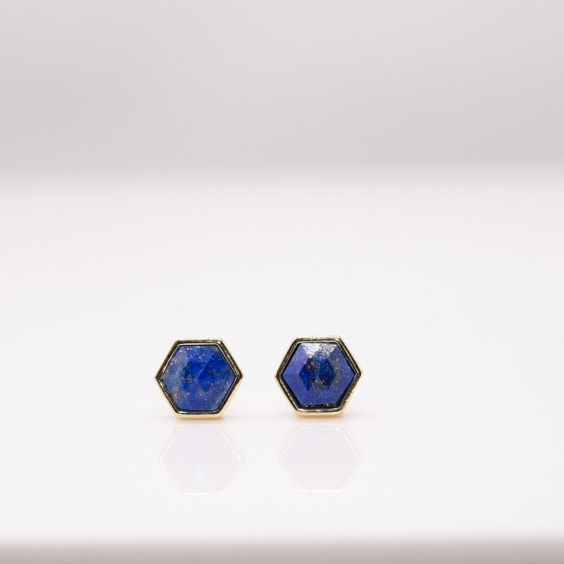Six pairs of small hexagon studs displayed in hand